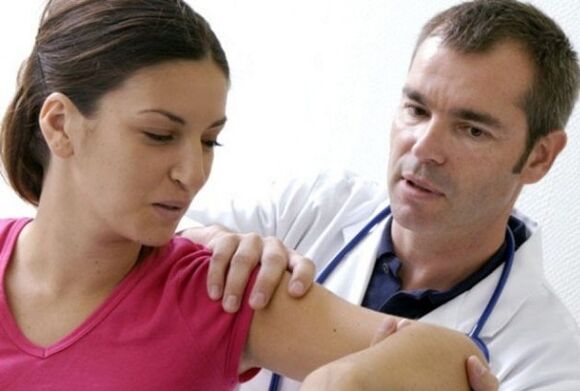doctor examines the shoulder joint with osteoarthritis